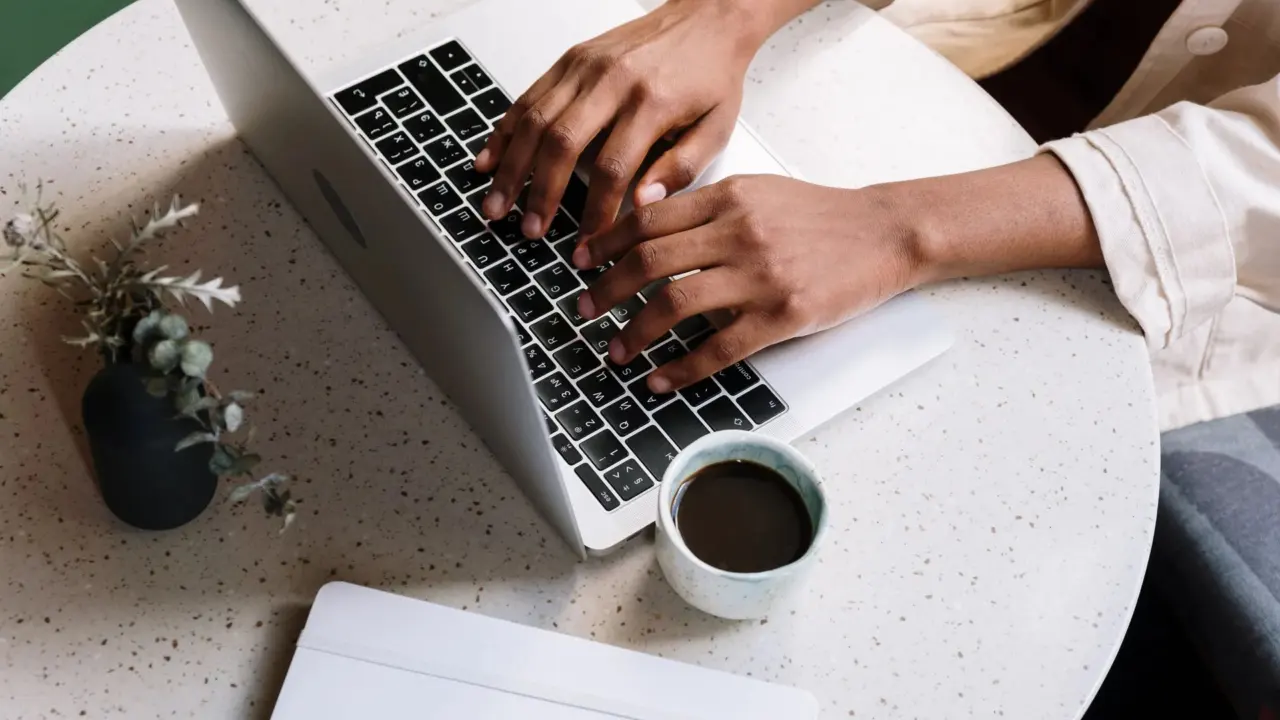 A blogger working on a laptop with a coffee